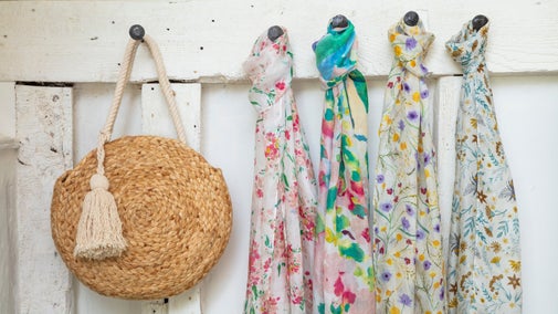 Scarves and a handbag hung on coat pegs